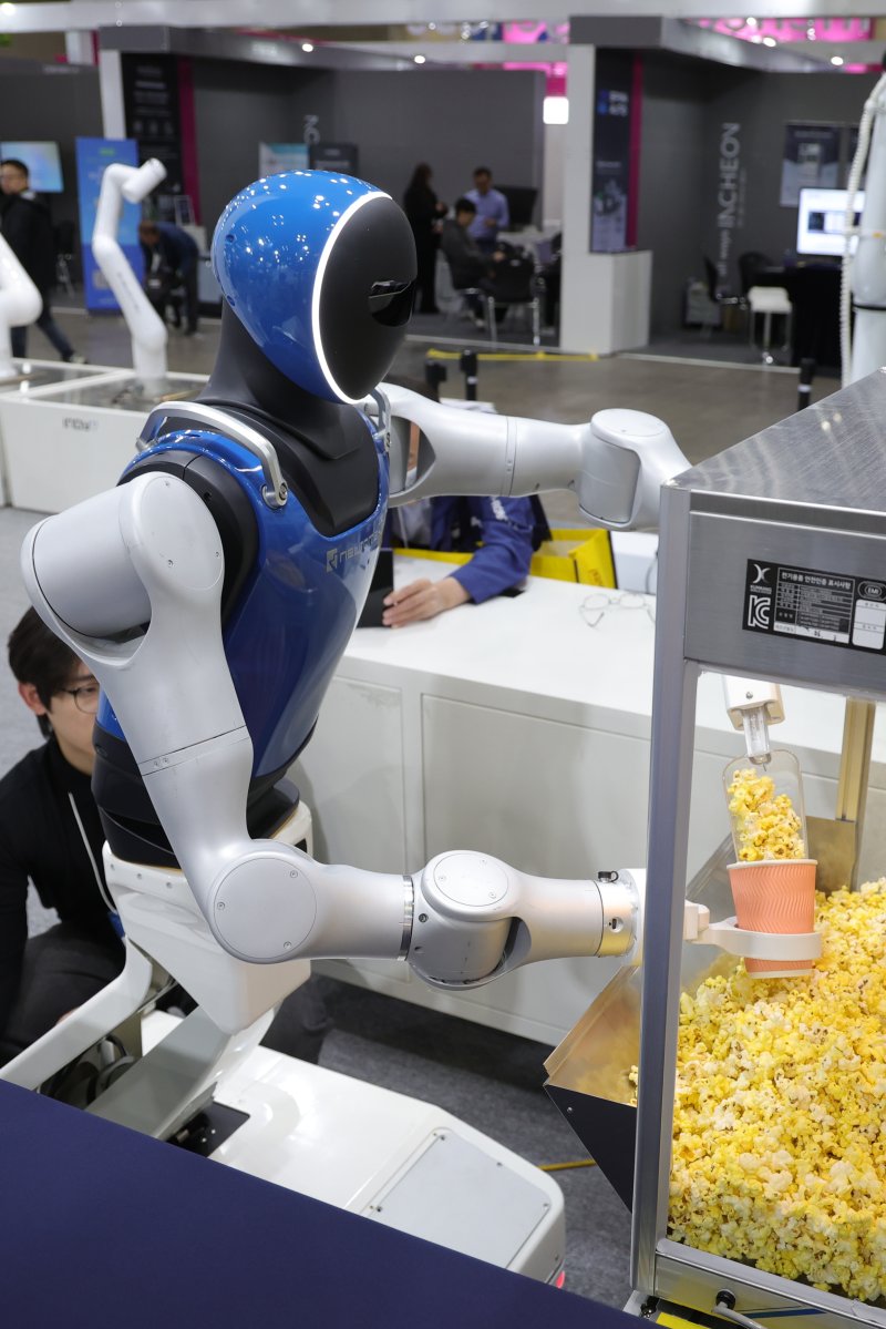 5일 경기도 고양시 킨텍스에서 열린 2025 로보월드에서 휴머노이드 로봇이 관람객의 주문에 팝콘을 담고 있다. 연합뉴스