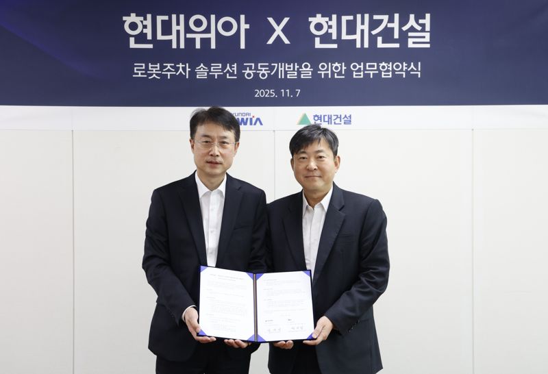 지난 7일 경기도 의왕시 <span id='_stock_code_011210' data-stockcode='011210'>현대위아</span> 의왕연구소에서 열린 &#39;로봇주차 솔루션 공동개발 업무협약식&#39;에서 김재영 <span id='_stock_code_000720' data-stockcode='000720'>현대건설</span> 기술연구원장(오른쪽)과 백익진 현대위아 모빌리티솔루션사업부 상무가 기념촬영을 하고 있다. 현대건설 제공