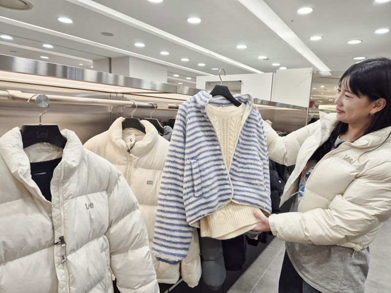 롯데백화점 부산본점 7층 &#39;LEE&#39; 매장에서 여성 고객이 다양한 겨울 아우터를 살펴보고 있다. <span id='_stock_code_023530' data-stockcode='023530'>롯데쇼핑</span> 제공 