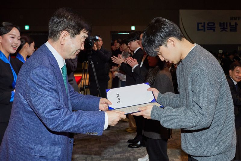 최평규 SNT그룹 회장(왼쪽)이 제12기 운해장학생들에게 장학증서를 수여하고 있다. SNT그룹 제공