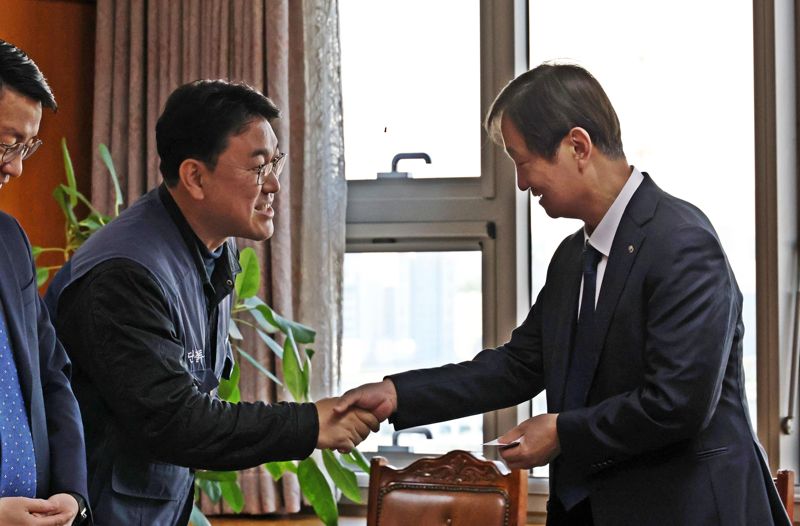 이찬진 금융감독원장과 김형선 전국금융산업노동조합 위원장이 지난 12일 서울 여의도 금융감독원에서 열린 간담회에서 명함을 교환하고 악수하고 있다. 금융노조 제공