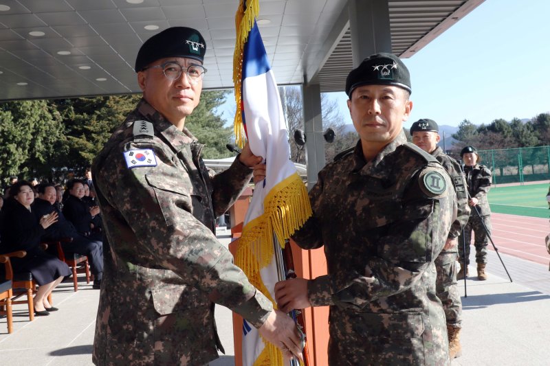 18일 강원 춘천시 육군 2군단 사령부에서 열린 제50&middot;51대 군단장 이취임식에서 주성운 지상작전사령관(왼쪽)이 정유수 신임 군단장에게 부대기를 이양하고 있다. 육군 2군단 제공