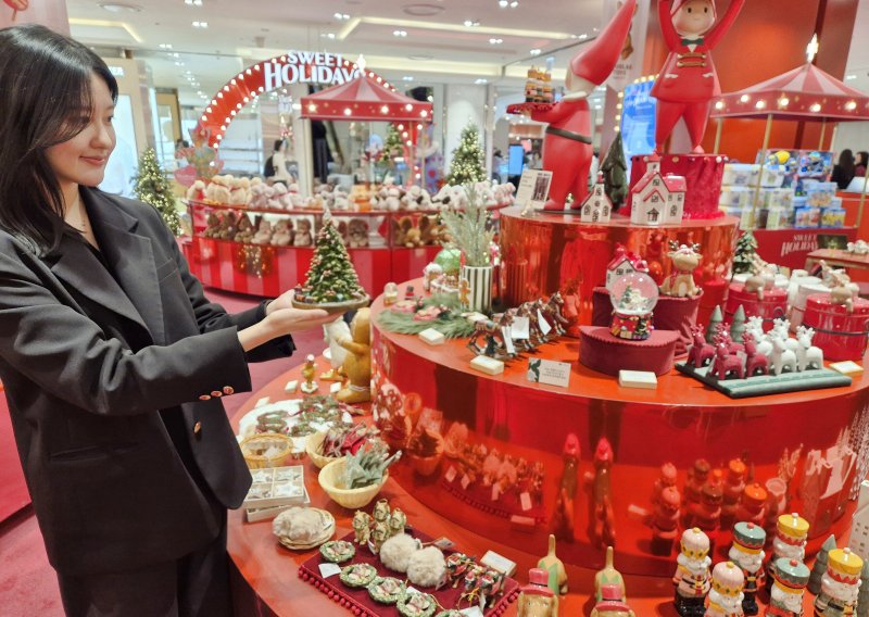 롯데백화점 부산본점 지하1층 크리스마스 마켓에서 한 여성 고객이 다양한 크리스마스 장식품을 살펴보고 있다. <span id='_stock_code_023530' data-stockcode='023530'>롯데쇼핑</span> 제공 