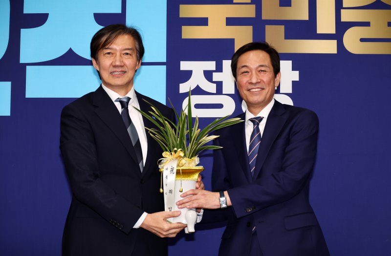 조국 조국혁신당 대표가 25일 오후 서울 여의도 국회에서 우상호 대통령실 정무수석에게 이재명 대통령이 보낸 취임 축하난을 전달받은 뒤 기념촬영하고 있다. 뉴시스