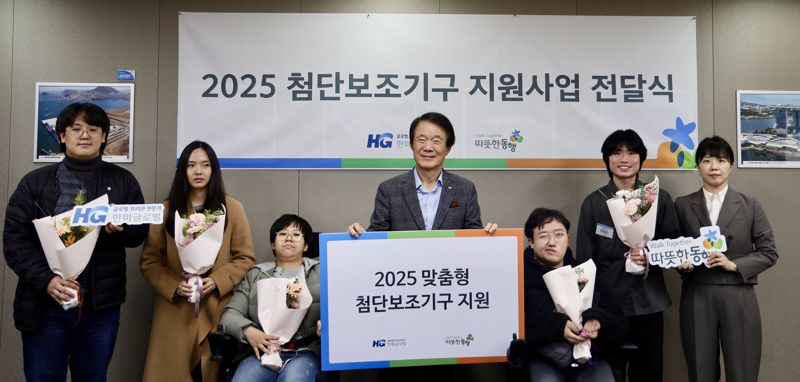 따뜻한동행 김두리 본부장(오른쪽 첫 번째)과 김종훈 이사장(가운데) 등 따뜻한동행 관계자들과 수혜 대상자들이 첨단보조기구 전달식에서 기념촬영을 하고 있다. <span id='_stock_code_053690' data-stockcode='053690'>한미글로벌</span> 제공