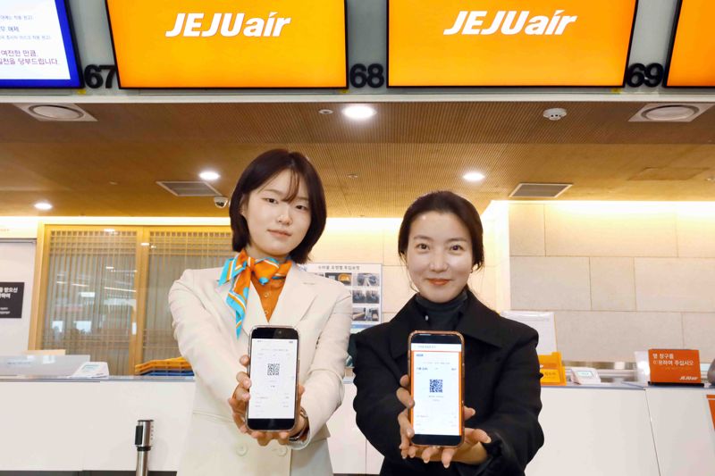 김포공항 국내선 청사 <span id='_stock_code_089590' data-stockcode='089590'>제주항공</span> 카운터에서 제이에이에스(JAS) 직원과 탑승객이 발급 받은 모바일 탑승권을 들어 보이고 있다. 제주항공 제공