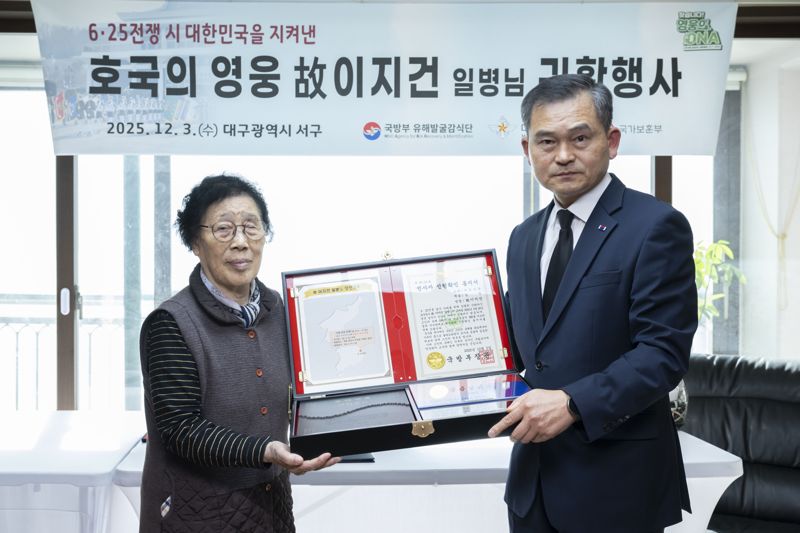 김종술 대구지방보훈청장(오른쪽)과 고 이지건 일병의 첫째 딸 이호분 씨(83세)가 함께 호국의 얼 함을 들고 기념사진을 촬영하고 있다. 국방부 제공