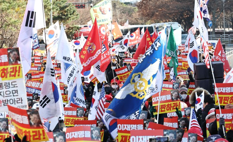 12·3 비상계엄 1주년인 3일 국회의사당역 3번 출구 앞에서 신자유연대 주최로 열린 이재명 대통령 재판 재개 촉구 집회에서 참가자들이 구호를 외치고 있다. 연합뉴스