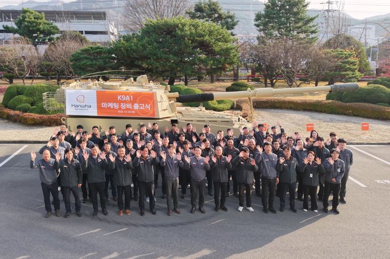 지난 2일 <span id='_stock_code_012450' data-stockcode='012450'>한화에어로스페이스</span> 창원3사업장에서 진행된 연구개발(R&amp;D) 및 마케팅용 K9A1 자주포 출하식에서 임직원들이 포즈를 취하고 있다. 한화에어로스페이스 제공