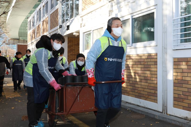 지난 3일 윤병운 <span id='_stock_code_005940' data-stockcode='005940'>NH투자증권</span> 대표이사와 임직원들이 서울 영등포구 쪽방촌에서 연탄을 전달하고 있다. NH투자증권 제공