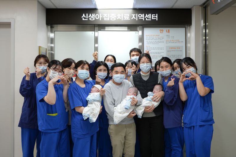 해운대백병원 신생아집중치료지역센터 의료진이 183일간의 치료 끝에 건강하게 퇴원한 세쌍둥이와 부모와 함께 기념 촬영하고 있다. 앞줄 왼쪽 두번째 정미림 센터장. 해운대백병원 제공