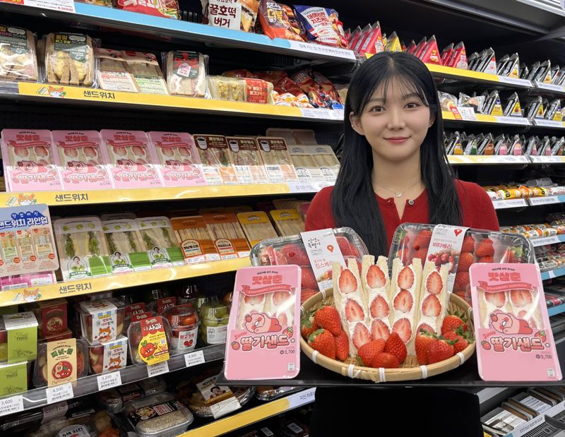 GS25에서 모델이 맛삼춘 딸기샌드위치와 생딸기를 들고 포즈를 취하고 있다. GS리테일 제공