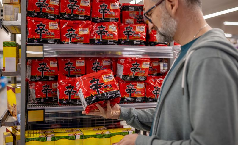 외국인 고객이 신라면 제품을 살펴보고 있다. <span id='_stock_code_004370' data-stockcode='004370'>농심</span> 제공