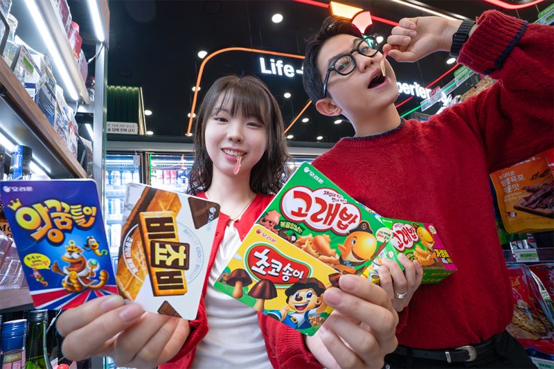 모델들이 <span id='_stock_code_271560' data-stockcode='271560'>오리온</span> '까까맛 교통카드' 4종을 소개하고 있다. 코리아세븐 제공