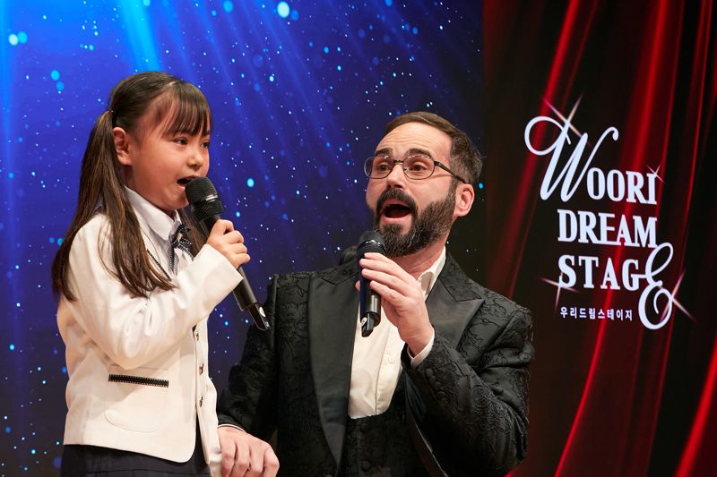 지난 13일 우리은행 본점에서 열린 '2025 우리드림스테이지' 에서 우리다문화어린이합창단 전즐리아사랑 단원과 그의 아버지가 함께 공연을 하고있다. 우리다문화장학재단 제공