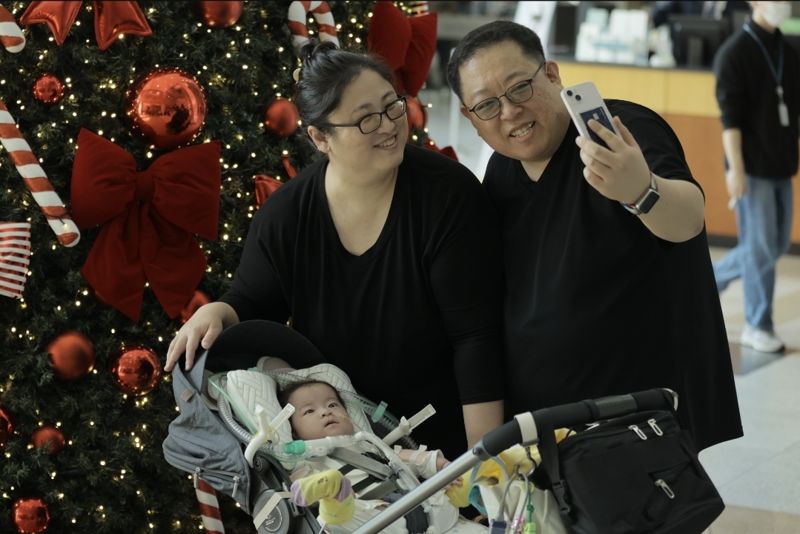 지난 12일 서울아산병원 신관 크리스마스 트리 앞에서 서린이 가족이 셀카를 찍고 있다. 서울아산병원 제공