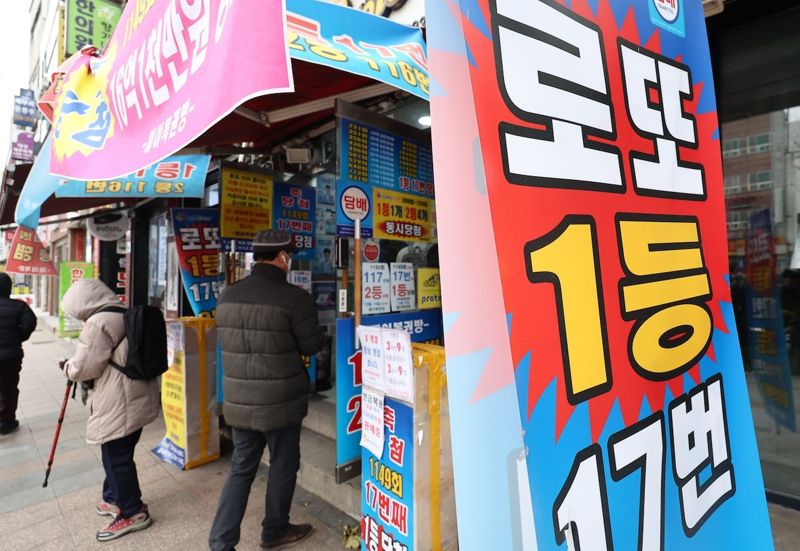 한 복권판매점 앞에 시민들이 복권 구입을 위해 줄을 서 있다../연합뉴스