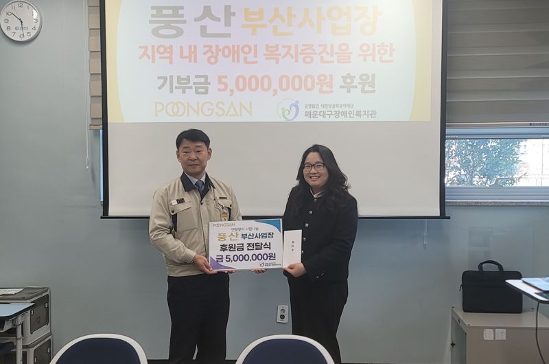 지난 23일 풍산 김석기 부산공장장(왼쪽)이 해운대구장애인복지관을 찾아 황미영 관장에 후원금을 전달하며 기념촬영하고 있다. 부산 해운대구장애인복지관 제공