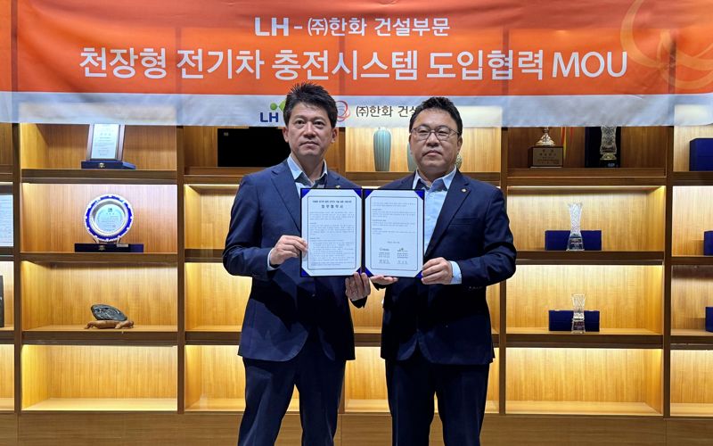 23일 LH 최한봉 공공주택전기처장(왼쪽)과 ㈜한화 건설부문 박광호 건축지원실장(오른쪽)이 차세대 천장형 전기차 충전 시스템 'EV에어스테이션'의 시범 도입을 위한 협약을 체결하고 기념촬영을 하고 있다. ㈜한화 건설부문 제공